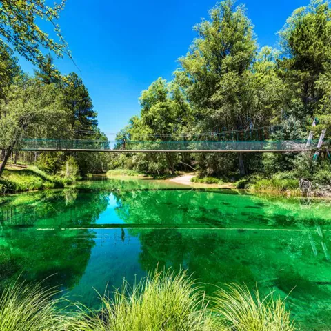 Puente colgante sobre aguas turquesa