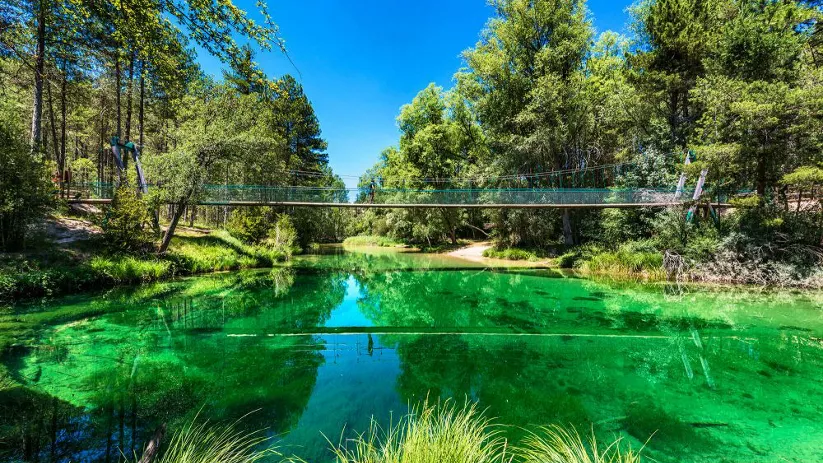 Puente colgante sobre aguas turquesa