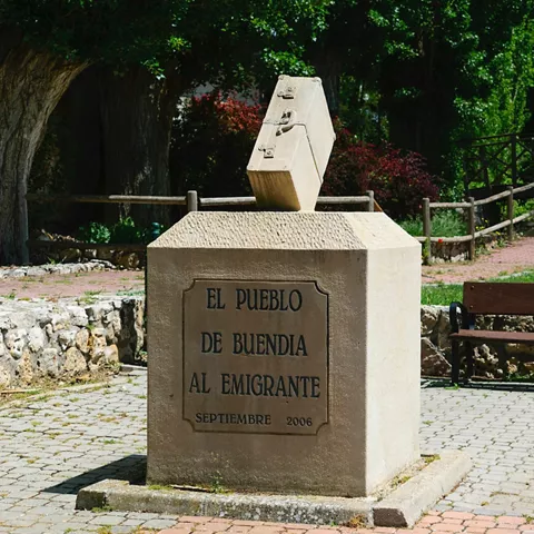 Monumento con inscripción en zona ajardinada del pueblo.