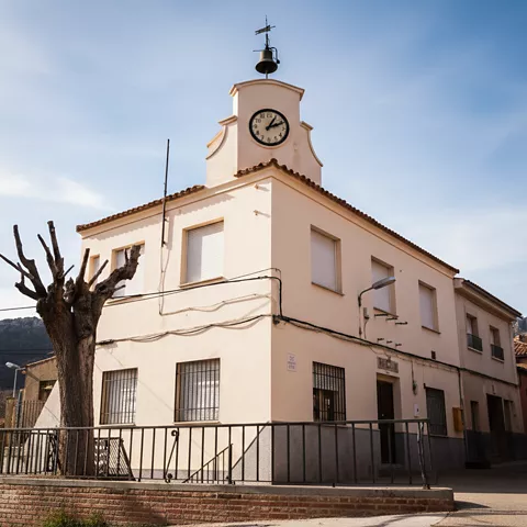 Edificio municipal con torre de reloj y campana