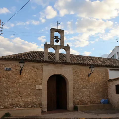 Pequeña ermita de piedra con espadaña y entorno rural