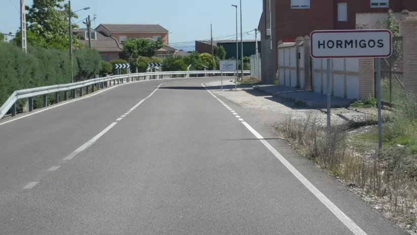 Carretera de entrada al pueblo con señal a la derecha