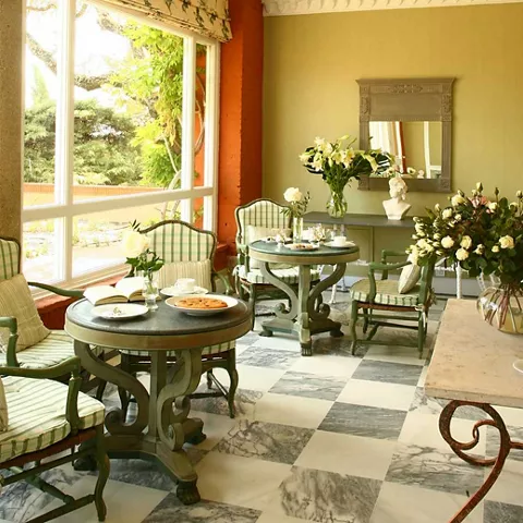 Sala luminosa con mesas redondas, flores y sillones