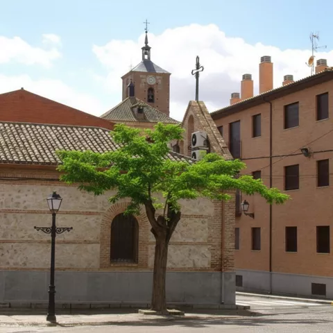 Iglesia y plaza con árbol y farolas