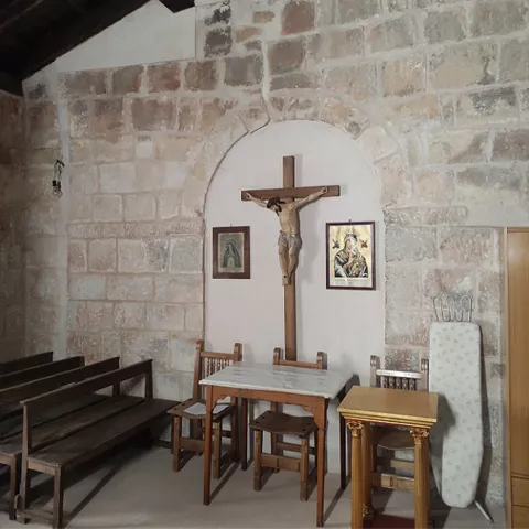 Capilla lateral con crucifijo y muro de piedra
