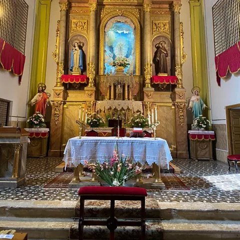Capilla con retablo dorado y bóveda decorada.