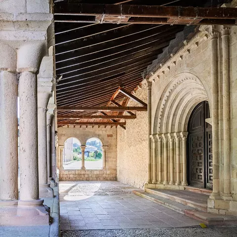 Entrada con arquivoltas y puerta de madera.