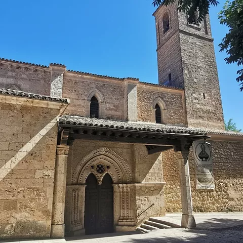 Portada gótica bajo pórtico de madera.