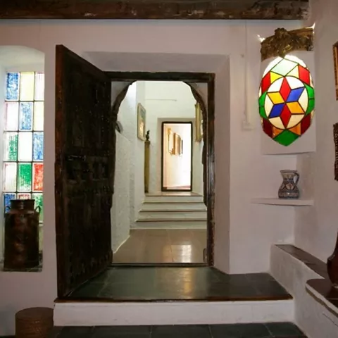 Pasillo interior con puerta de madera, cerámica tradicional y vidriera