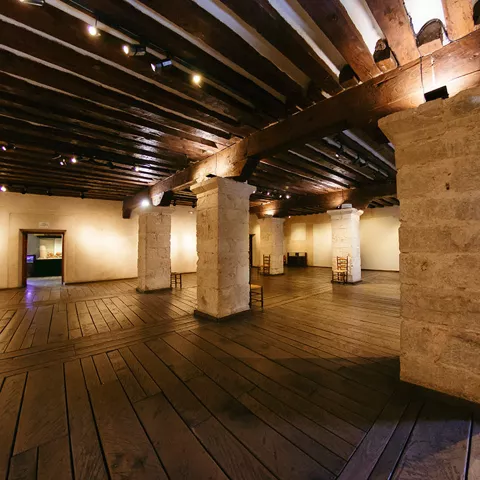 Gran sala diáfana con pilares de piedra y techo de madera