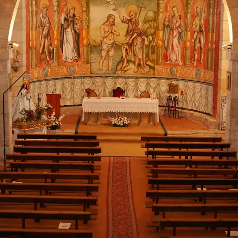 Interior con bancos y retablo pintado