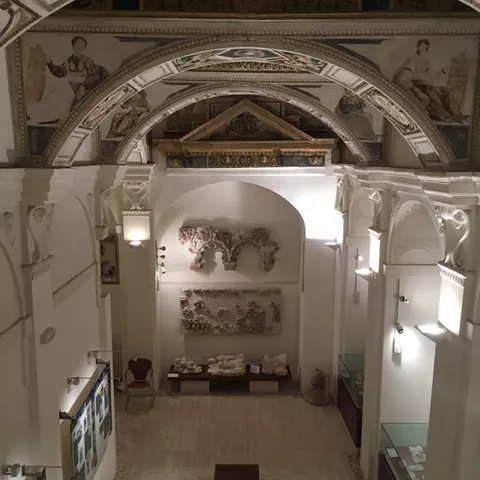 Interior con bóveda pintada y esculturas en sala expositiva.