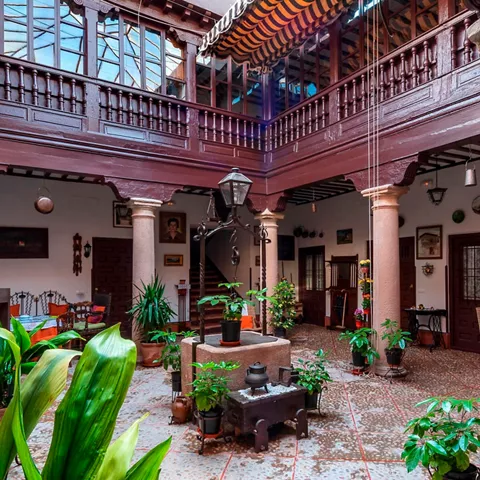 Patio tradicional con pozo central y balcones de madera