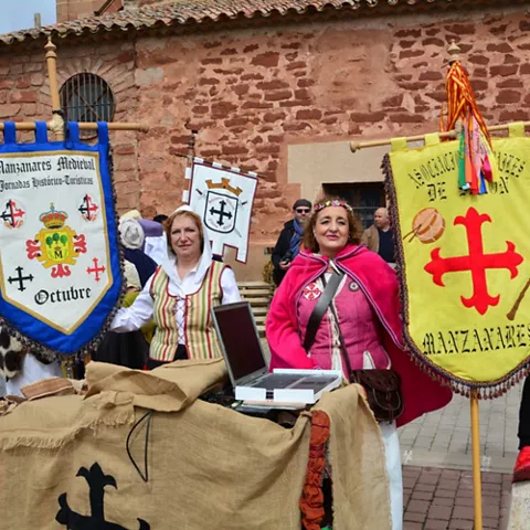 Estandartes medievales junto a edificio de piedra
