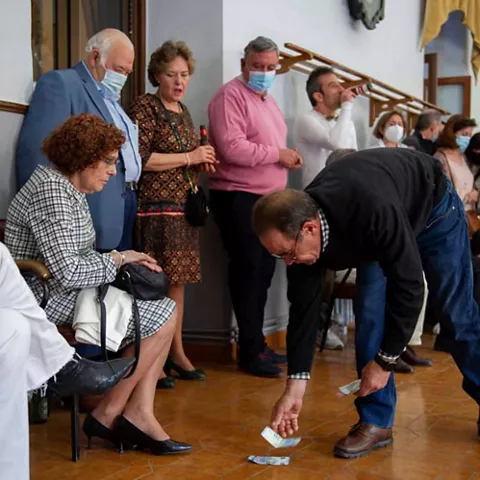 Participantes recogiendo billetes del suelo en juego tradicional