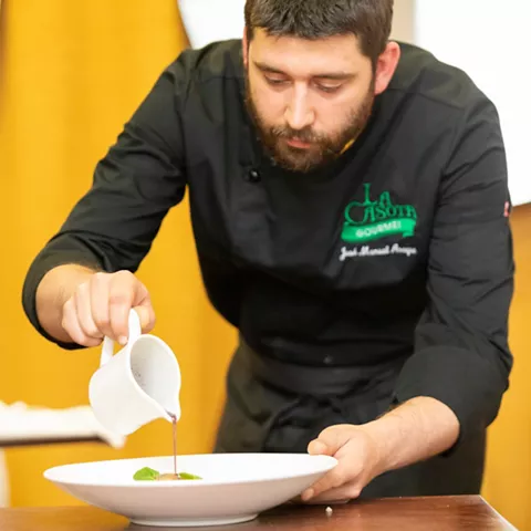 Chef sirviendo salsa en mesa