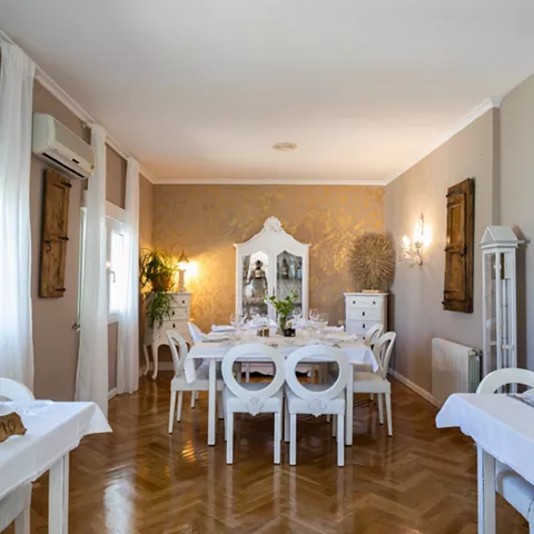 Sala luminosa con mesas vestidas en blanco