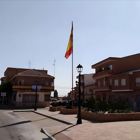 Plaza con bandera alta y edificios residenciales