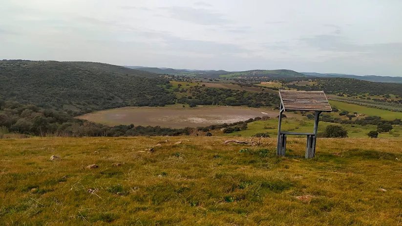 Mirador rural con estructura de madera frente a una laguna natural