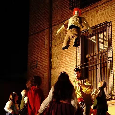 Fiesta popular con muñeco elevado y bailarines.