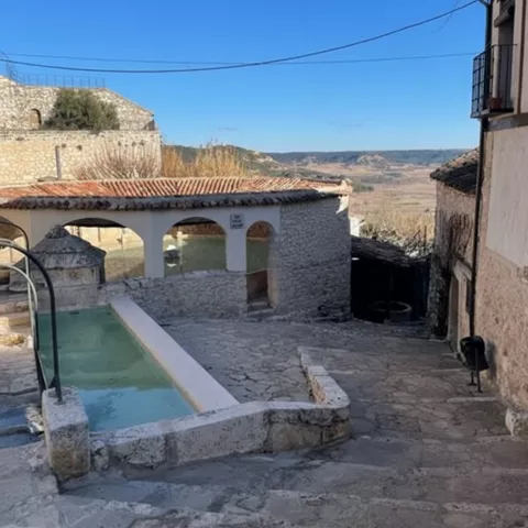 Lavadero con arcos abierto al paisaje rural.