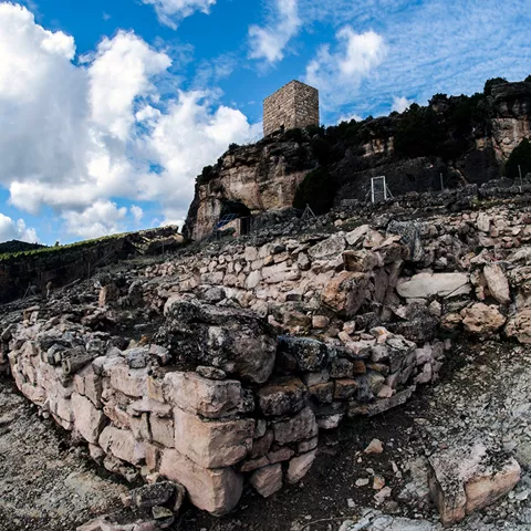 Ruinas de piedra con torre sobre acantilado