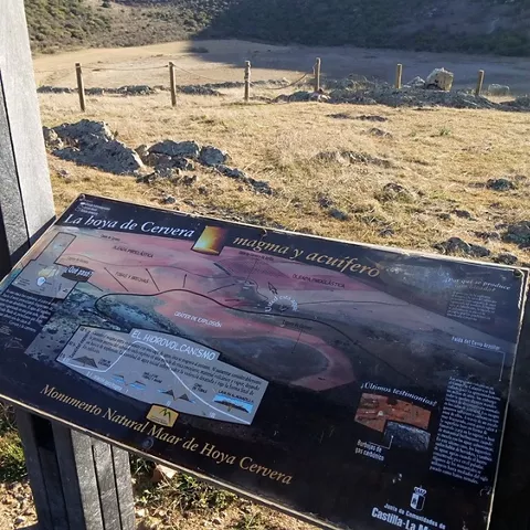 Panel informativo junto a una amplia hoya natural.