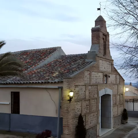 Edificio tradicional de ladrillo con espadaña al atardecer