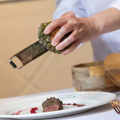 Chef rallando trufa sobre carne