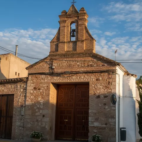 Ermita de piedra con espadaña y puerta de madera