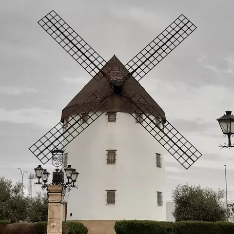 Molino blanco con aspas y farolas antiguas