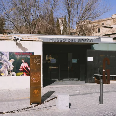 Entrada moderna de museo con cartel expositivo en la fachada.