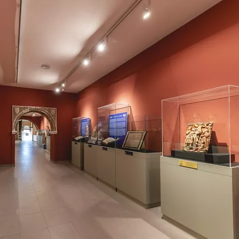 Galería con vitrinas y esculturas sobre pedestales.