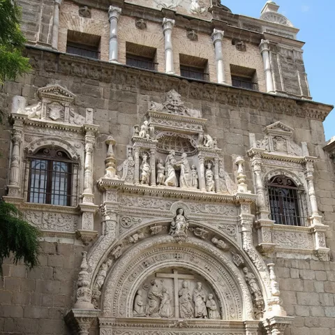 Fachada de piedra con portada ornamentada y relieves escultóricos.