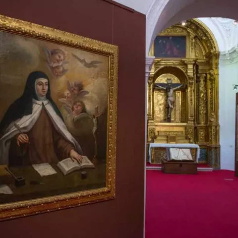 Sala de museo con pinturas religiosas y retablo dorado