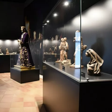 Imágenes talladas expuestas en vitrinas de cristal.