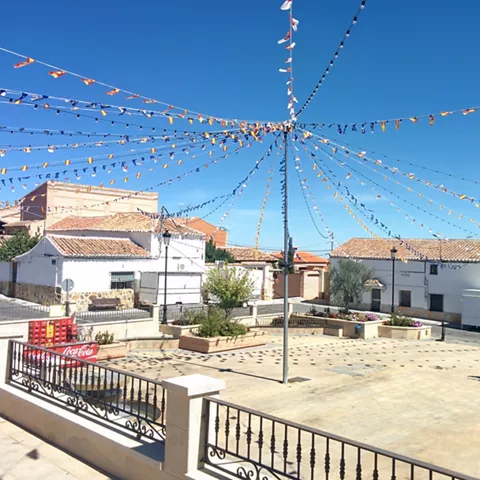 Plaza con banderines festivos sobre casas blancas
