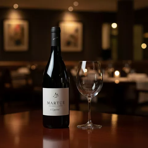 Botella de vino y copa vacía con fondo desenfocado de comedor elegante.