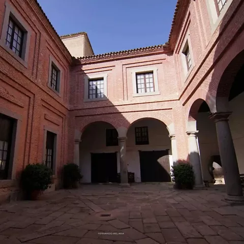 Patio interior con galerías de arcos y suelo de piedra