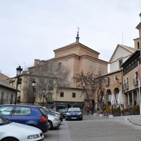 Plaza con edificios históricos y fachada institucional de piedra y ladrillo.