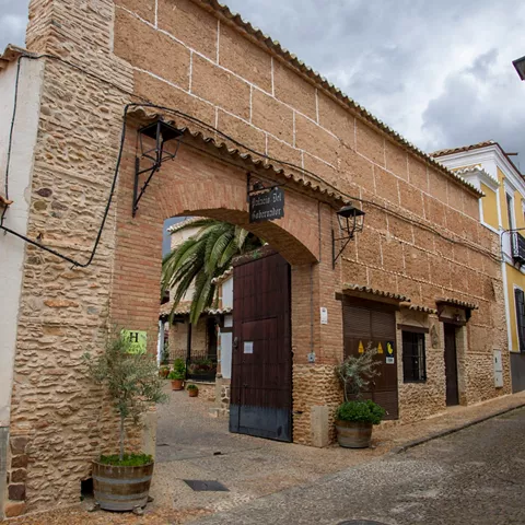 Arco de piedra con puerta en calle empedrada