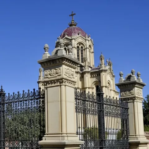 Reja de hierro ante edificio monumental.