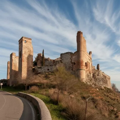 Fortaleza en ruinas sobre una colina junto a la carretera