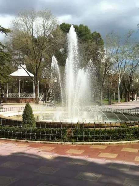 Fuente con chorros de agua y glorieta al fondo.