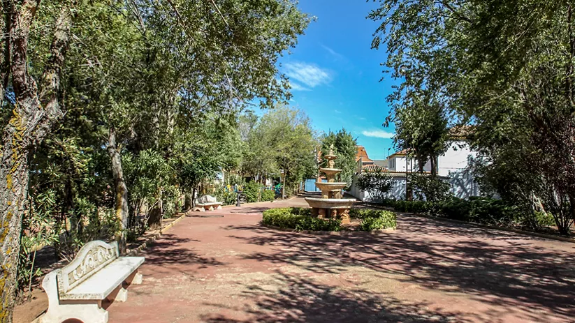 Parque con fuente y arbolado.
