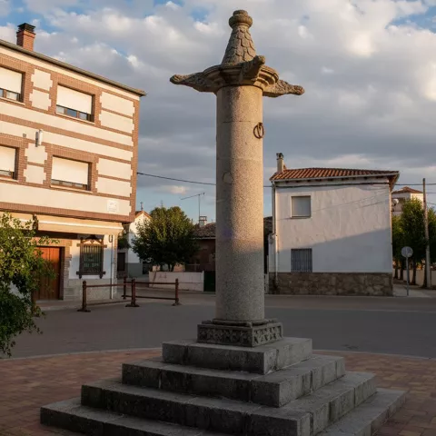 Cruz de piedra sobre pedestal en una plaza