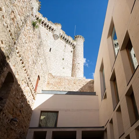 Patio interior con muros históricos y edificio actual.
