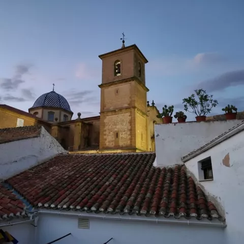 Conjunto de tejados con torre y cúpula al atardecer