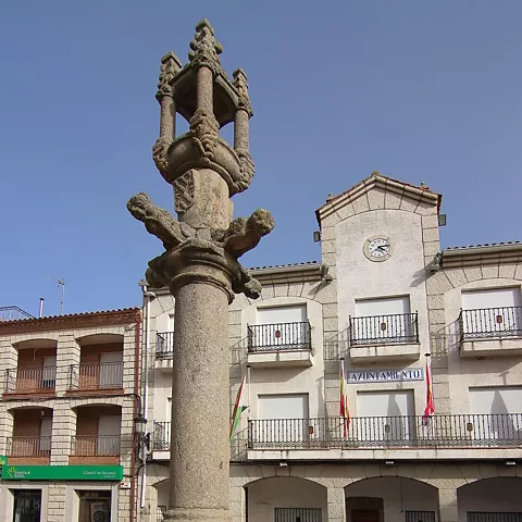 Columna de piedra esculpida en plaza urbana