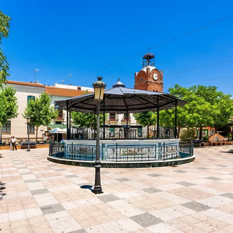 Plaza con quiosco central y arbolado.